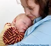 Un bébé dort dans les bras de sa mère.